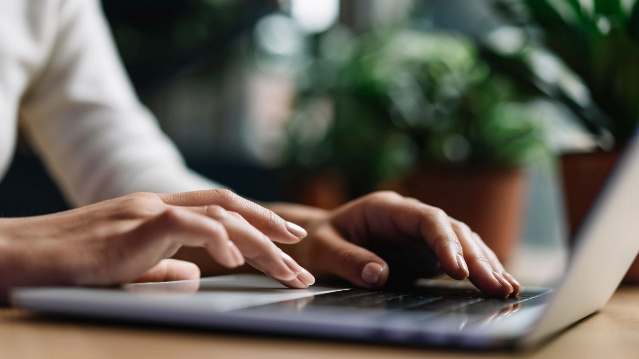 Hände tippen auf der Tastatur eines Laptops