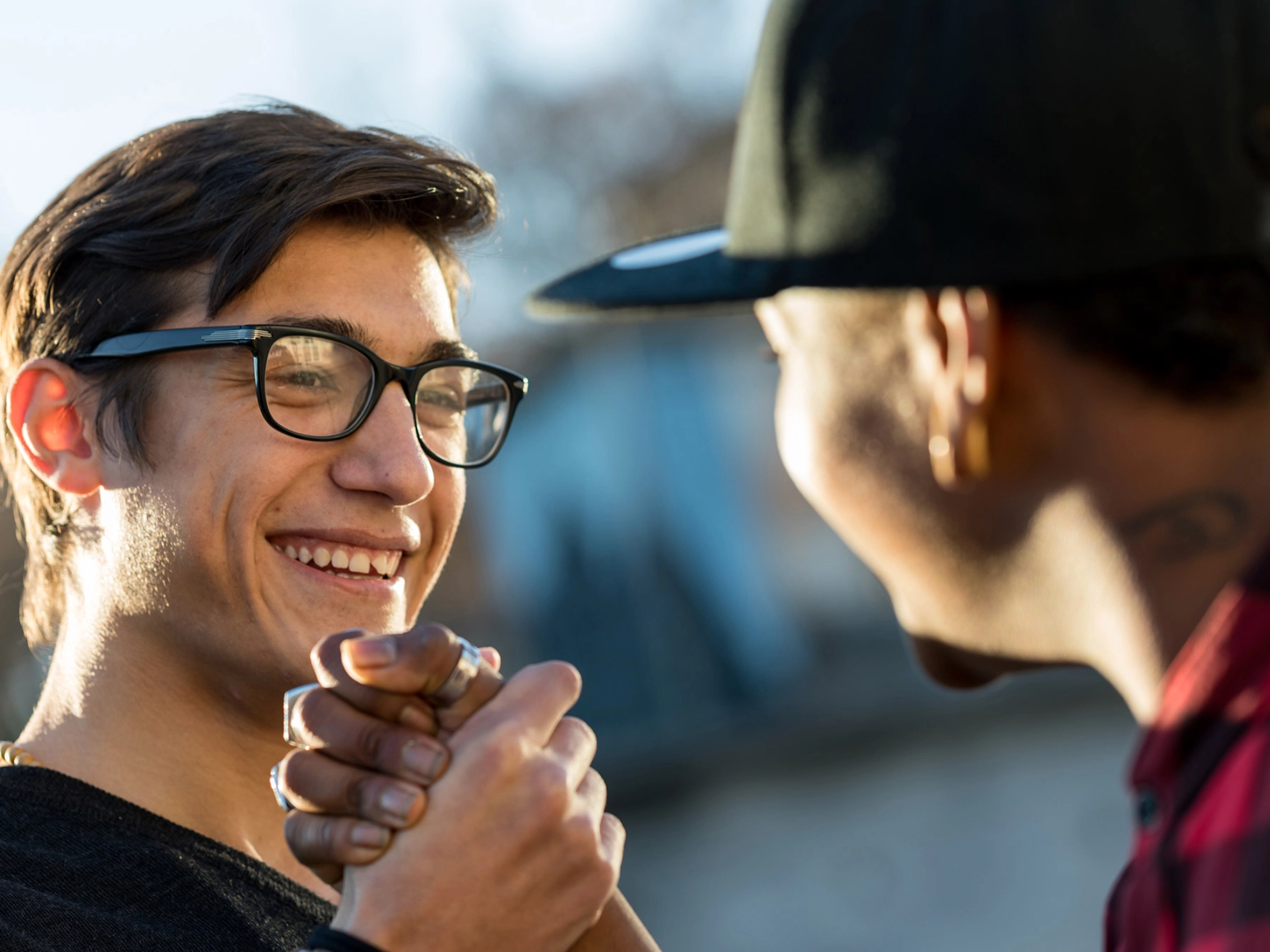 Zwei junge Männer geben sich freudig die Hand